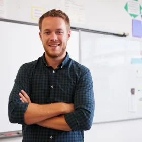 depositphotos_109964764-stock-photo-confident-male-teacher-in-classroom